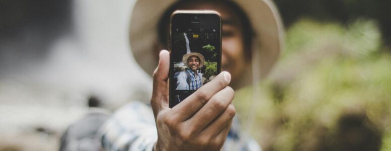 View of an influencer through the lens of a smartphone, which they're holding up to record a social media post