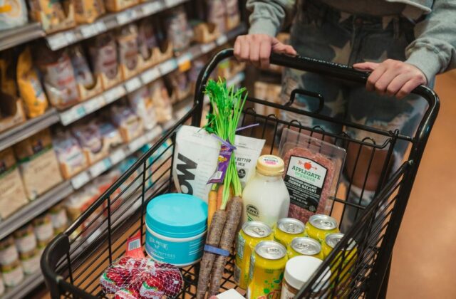 Instacart shopper pushing a cart full of groceries.