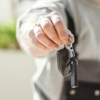 Man handing off keys to a rental car.