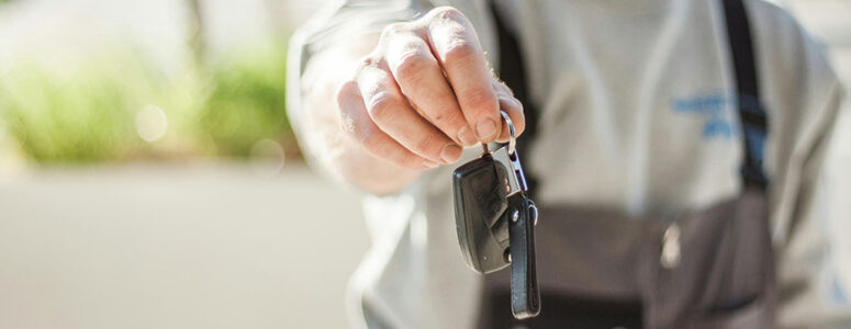 Man handing off keys to a rental car.