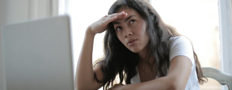 Image of a woman who is dissatisfied with her job on her laptop.