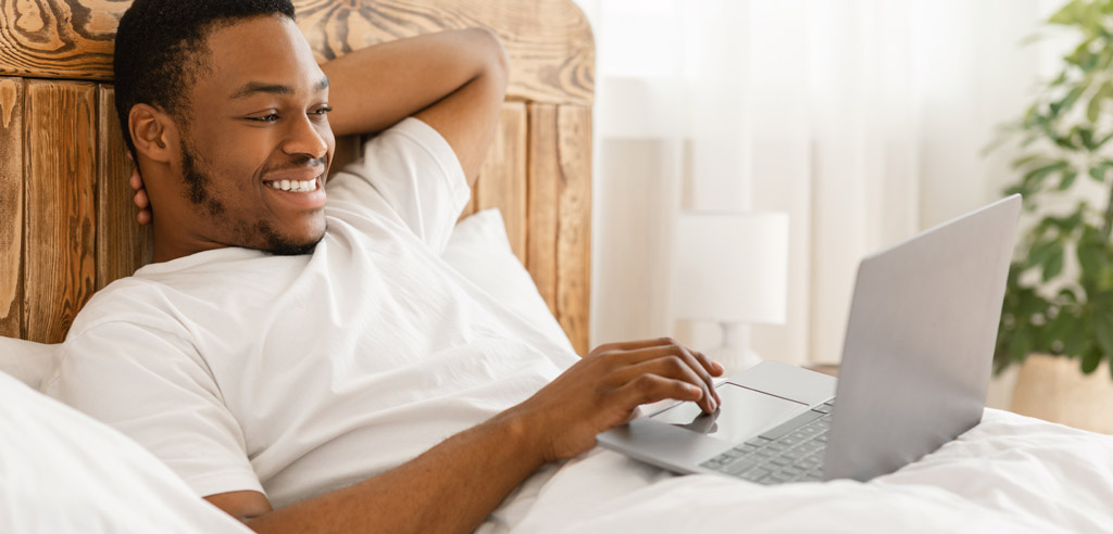 Man lying in bed getting paid to watch ads