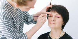 Professional makeup artist applying pink eye shadow to a client