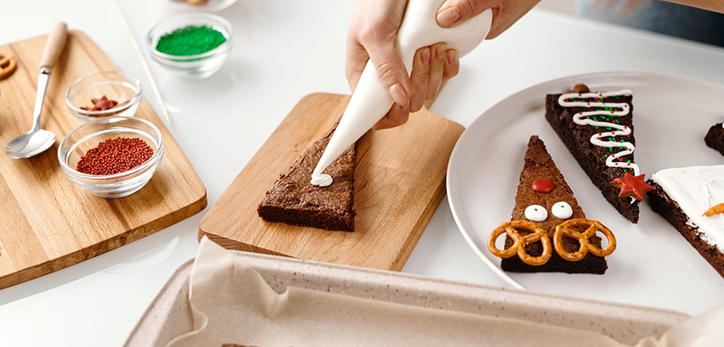 a home baker puts icing on a brownie