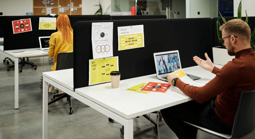 A manager introducing unfavorable policy to remote workers in a hybrid meeting.