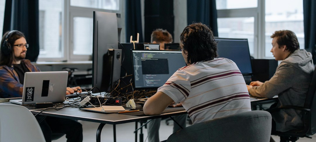 Group of Meta employees working on computers.