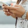 Close view of a woman's hands holding a smartphone.