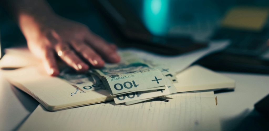 Woman separating a few bills allocated to paying payday loan fees.