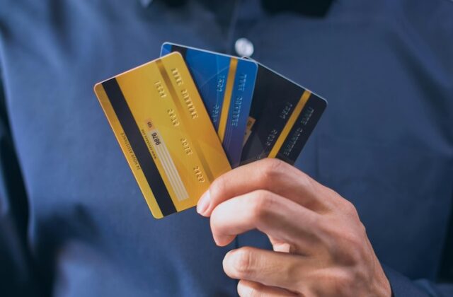 Closeup of a person holding three credit cards.