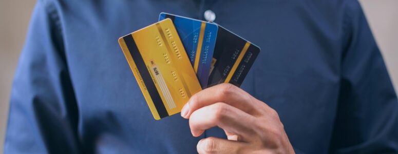 Closeup of a person holding three credit cards.