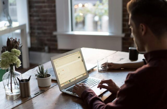 Man at his desk using his laptop to pick a side hustle.