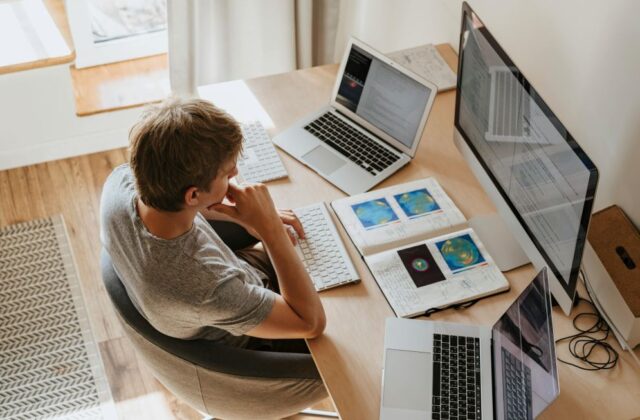 A polyworker staring at multiple screens while working.