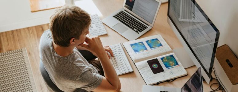 A polyworker staring at multiple screens while working.