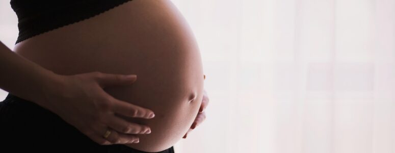 Pregnant woman cradling her belly.