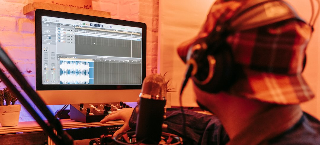 Music producer mixing recording tracks in a studio.