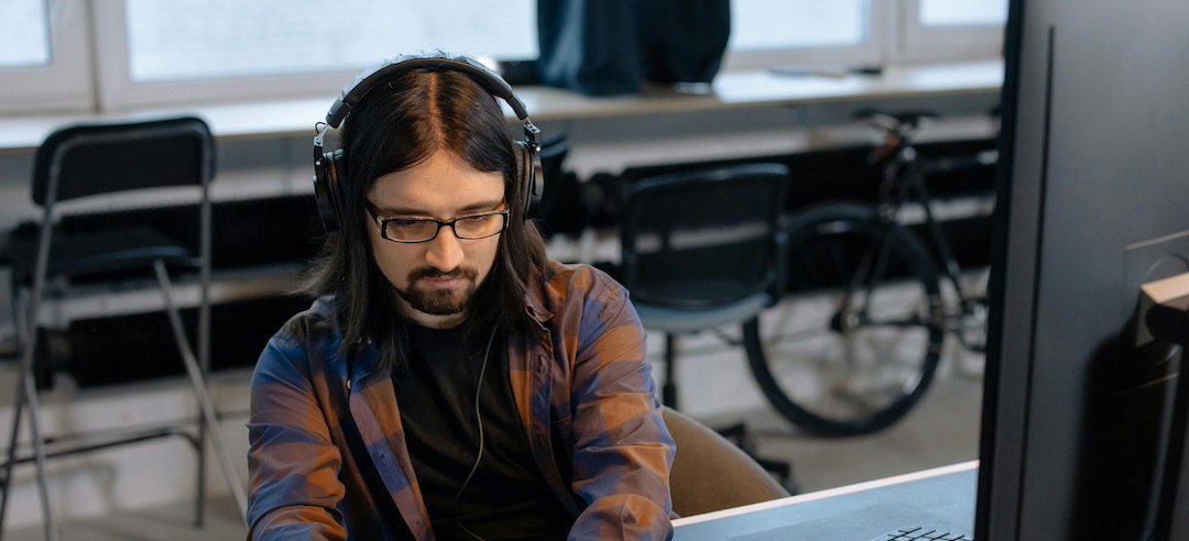 Programmer using AI coding software in an office.
