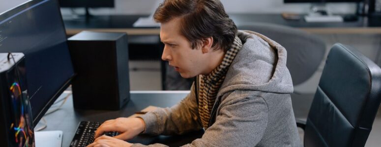 Programmer writing code on an office computer.