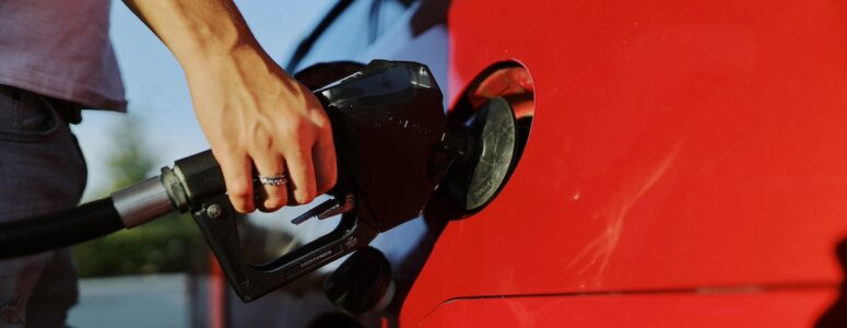 Closeup of a person pumping gas into their car.