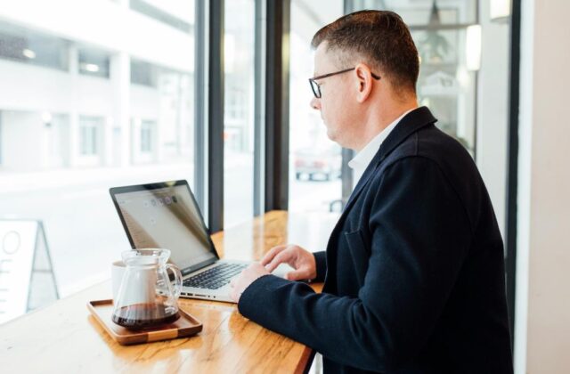 Real estate virtual assistant working on his laptop at a coffee shop.