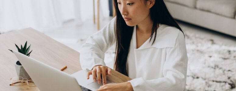 Job-hunter sitting and using her laptop to access Remote.co and look for gigs.