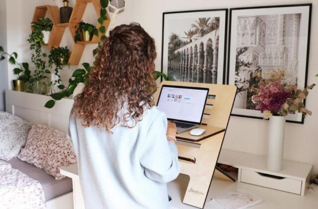 E-commerce seller sitting at her computer working on her online selling side hustle.