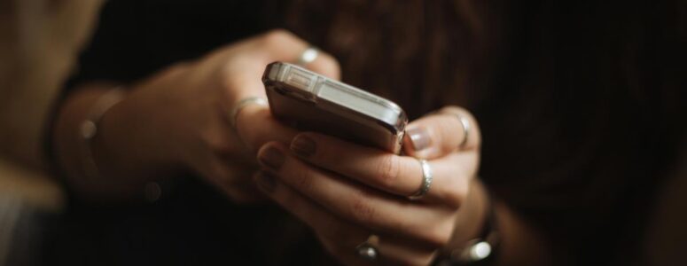 Close view of a woman holding a smartphone and using a side hustle app.