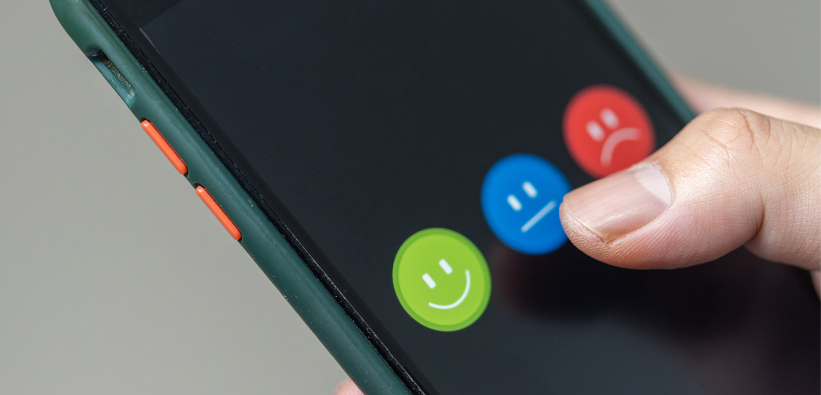 Closeup of someone holding a smartphone with different icons representing positive, neutral and negative reviews