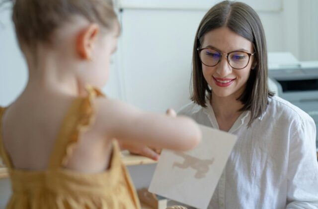 Child and adult looking at a drawing, representing a special education aide interacting with a student