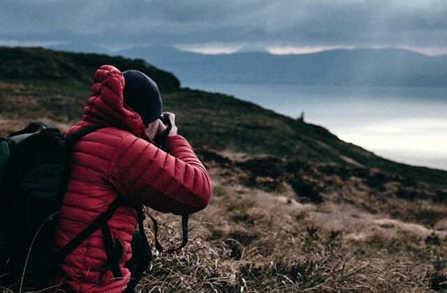 Photographer capturing a landscape shot with a long-distance camera to sell on stock photo sites