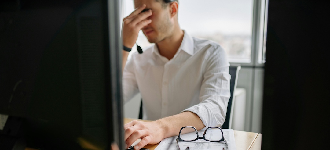 Stressed employee working on his laptop.