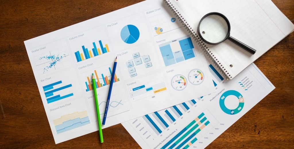 Freelance medical writer studying printed charts and graphs from a study.