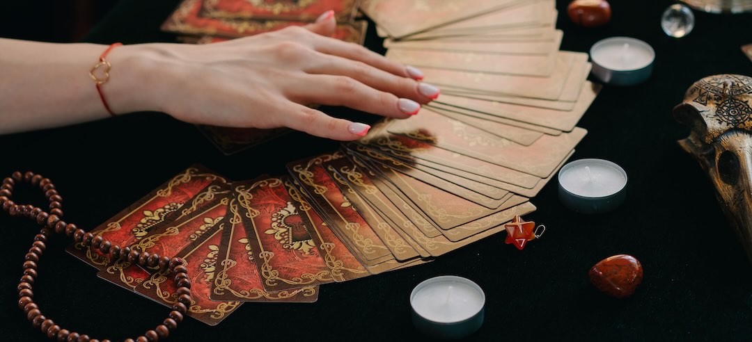 Closeup of a spread deck of tarot cards on a table.