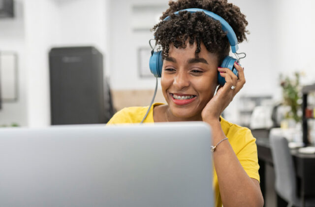 Transcriptionist wearing headphones and working at their laptop.