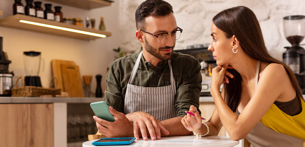 Man and woman sitting in a kitchen discussing side hustle business ideas