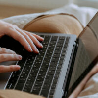 Close view of a freelance writer's hands on their keyboard.