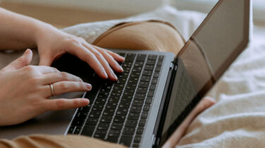 Close view of a freelance writer's hands on their keyboard.