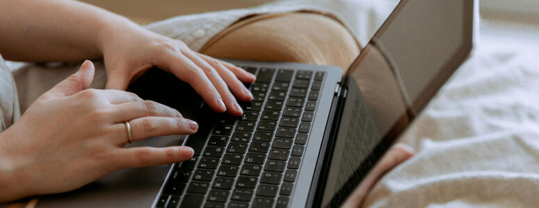 Close view of a freelance writer's hands on their keyboard.