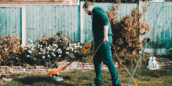 Professional landscaper mowing a lawn as part of their landscaping side hustle