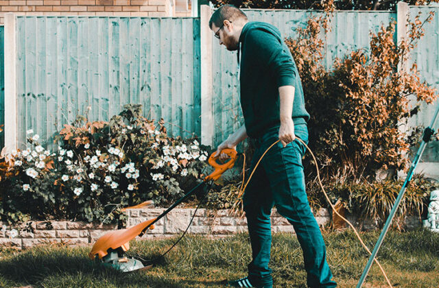 Professional landscaper mowing a lawn as part of their landscaping side hustle