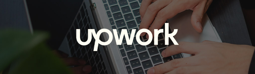 Upwork logo against a darkened background showing someone typing on a laptop (close view)