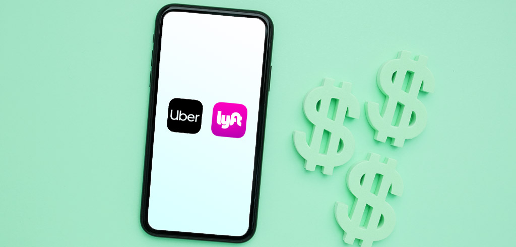 Smartphone with Uber and Lyft on the screen next to three dollar signs