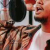 Voice actor recording for a commercial in his home studio.