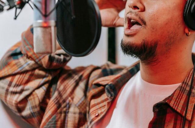 Voice actor recording for a commercial in his home studio.