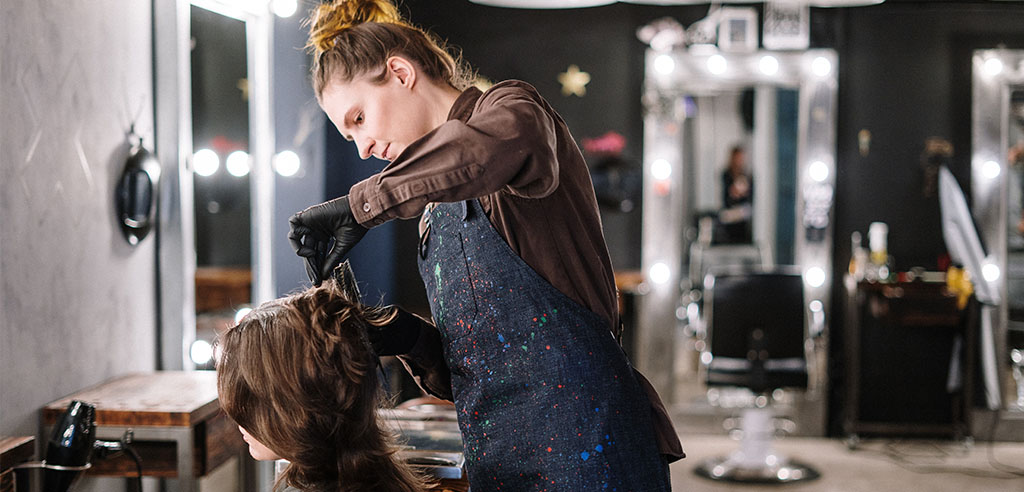 a stylist is styling the hair of her client