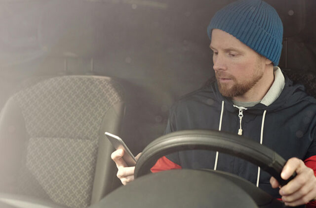 Rideshare driver behind the wheel of a car.