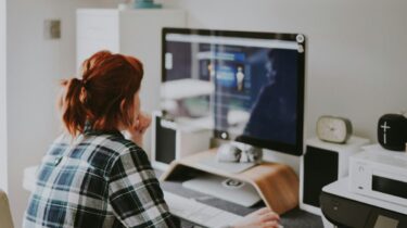 Data entry clerk sitting at a desktop computer working on their side hustle.