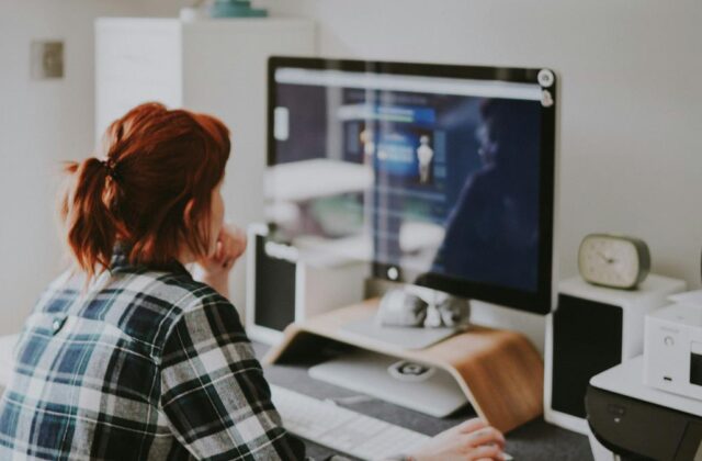 Data entry clerk sitting at a desktop computer working on their side hustle.