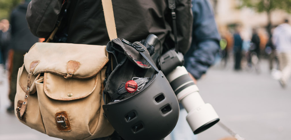 Person carrying a travel bag and camera.