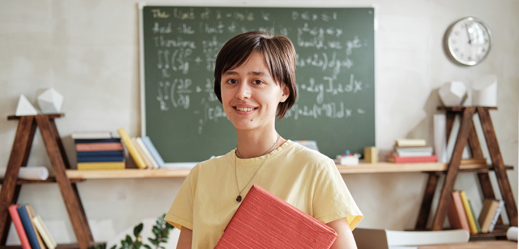 Substitute teacher standing in classroom in front of a blackboard