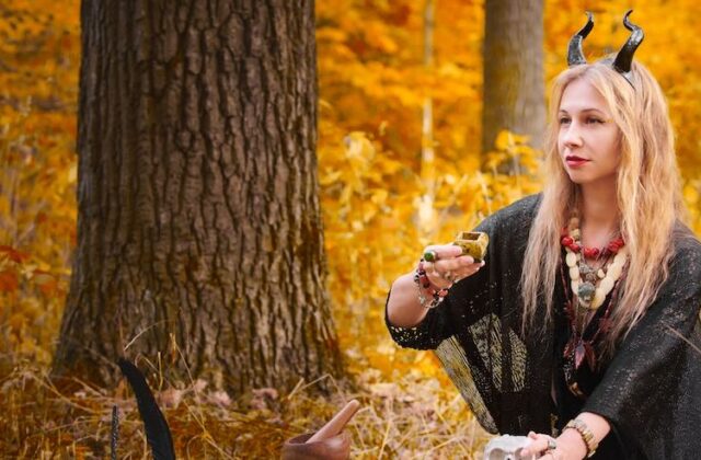 Woman engaging in witchcraft ritual outdoors.